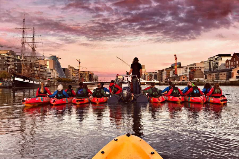 A group of kayakers on the River Liffey at sunset in Dublin Docklands